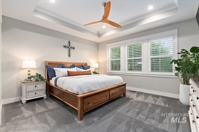 carpeted bedroom featuring a tray ceiling, baseboards, multiple windows, and recessed lighting