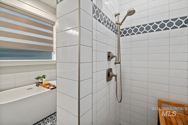 full bath featuring tiled shower and tile walls