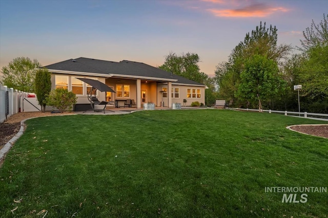 back of property at dusk featuring a patio area