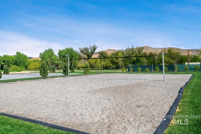 view of home's community featuring volleyball court, fence, and a mountain view