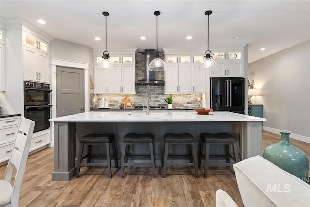 kitchen featuring black appliances, wall chimney exhaust hood, backsplash, white cabinets, and recessed lighting