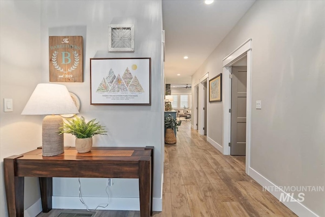 hall with wood finished floors, recessed lighting, and baseboards