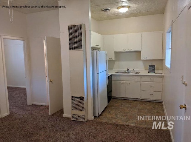 kitchen featuring sink, white cabinets, dark carpet, and white refrigerator