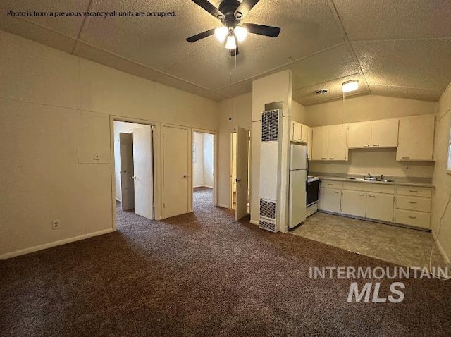 kitchen with ceiling fan, white refrigerator, carpet floors, and white cabinetry