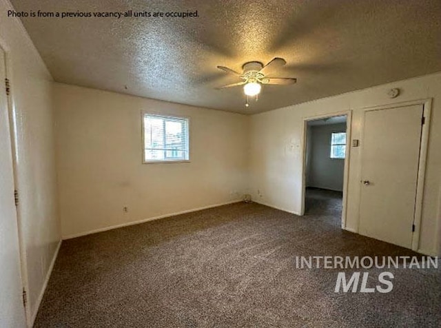 carpeted spare room with ceiling fan and a textured ceiling