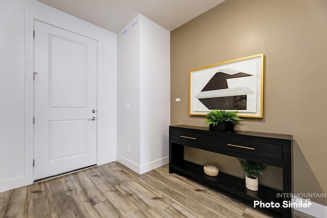 foyer entrance featuring baseboards and light wood-style floors