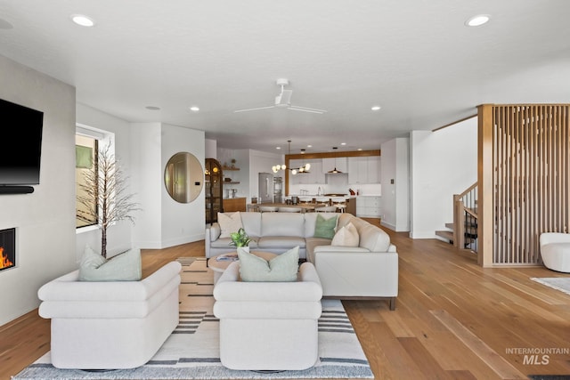 885 E Joplin Ln, Eagle, ID 83616 - living area with light wood-style flooring, stairway, recessed lighting, a glass covered fireplace, and ceiling fan
