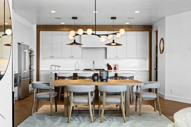 885 E Joplin Ln, Eagle, ID 83616 - kitchen featuring wood finished floors, white cabinetry, decorative light fixtures, high quality fridge, and recessed lighting