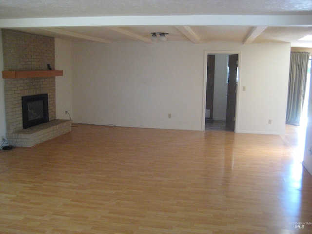 11254 W Camas St, Boise, ID 83709 - unfurnished living room with beamed ceiling, light wood-type flooring, and a brick fireplace