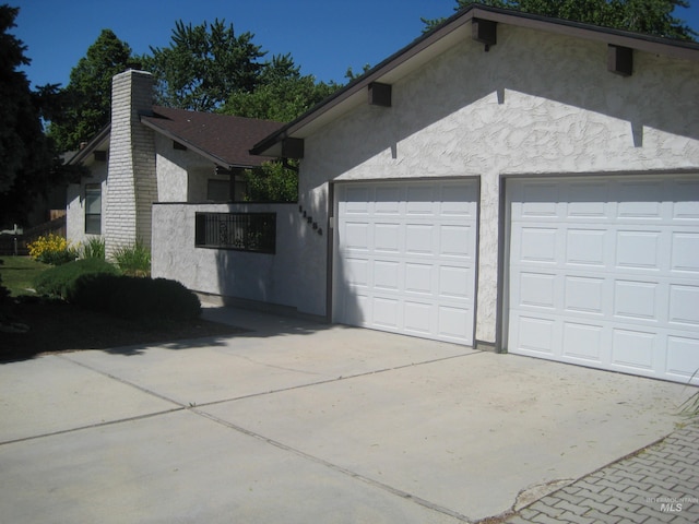 11254 W Camas St, Boise, ID 83709 - view of side of home featuring stucco siding, a chimney, and driveway