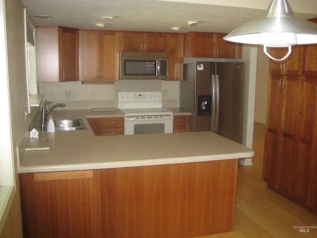 11254 W Camas St, Boise, ID 83709 - kitchen with appliances with stainless steel finishes, a sink, a peninsula, light countertops, and brown cabinets