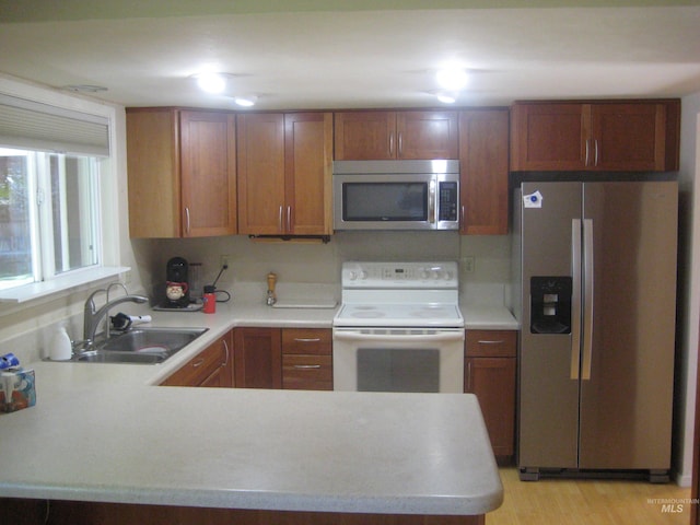 11254 W Camas St, Boise, ID 83709 - kitchen featuring stainless steel appliances, a sink, light countertops, a peninsula, and brown cabinetry