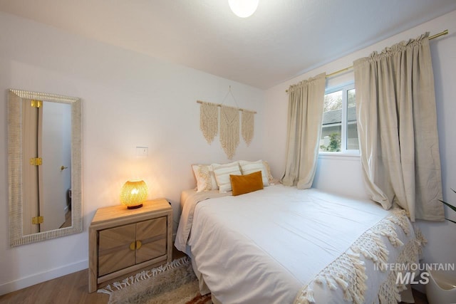 bedroom featuring wood finished floors and baseboards