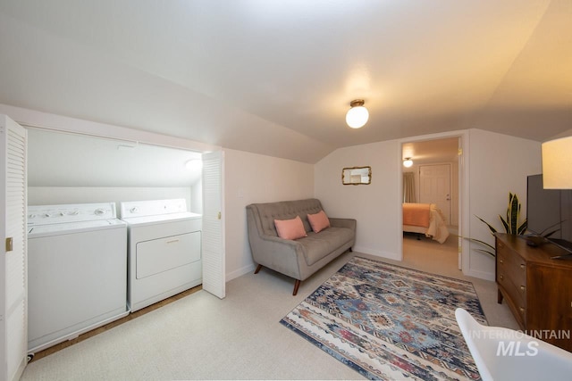 living area with light carpet, washer and clothes dryer, vaulted ceiling, and baseboards