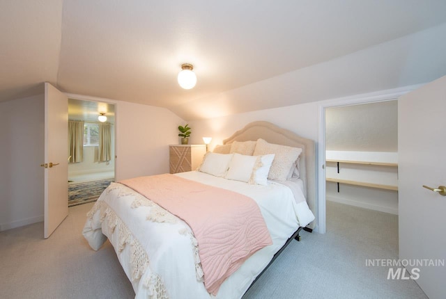 carpeted bedroom with lofted ceiling and baseboards