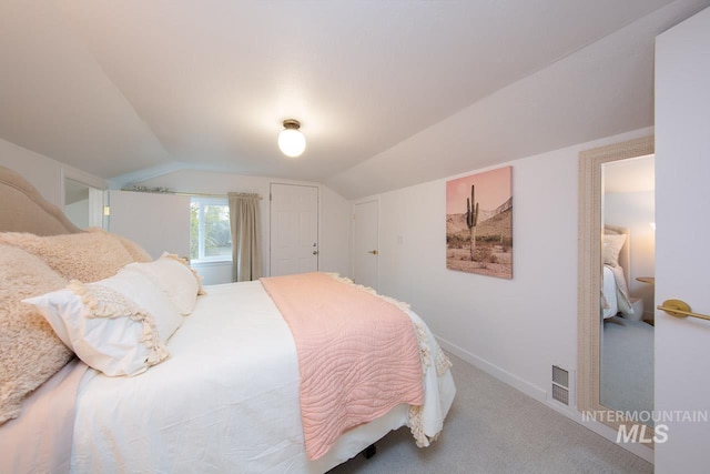 bedroom with carpet floors, visible vents, vaulted ceiling, and baseboards