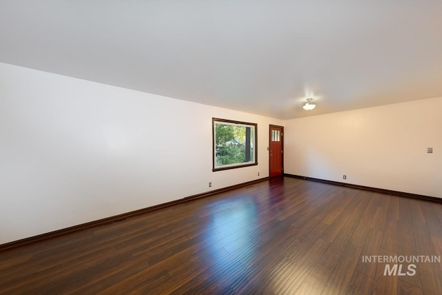 unfurnished room featuring dark wood finished floors and baseboards