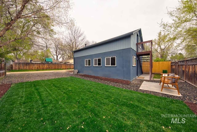 view of home's exterior featuring stairs, a fenced backyard, a yard, and a patio