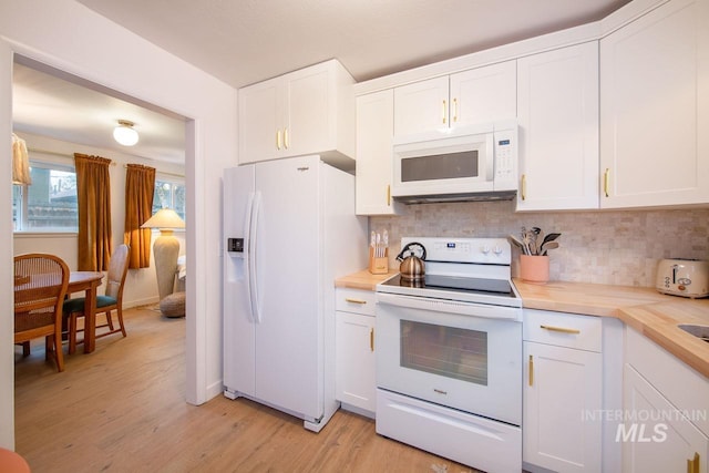 kitchen featuring white appliances, white cabinetry, light wood finished floors, and backsplash