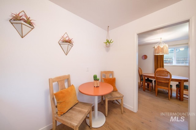 dining space featuring baseboards and light wood finished floors