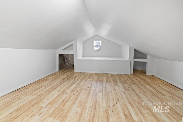 bonus room featuring lofted ceiling and light hardwood / wood-style flooring