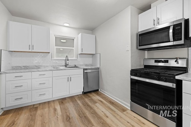 kitchen featuring light hardwood / wood-style floors, sink, white cabinets, and appliances with stainless steel finishes