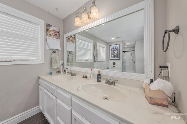 full bathroom featuring a sink, double vanity, baseboards, and a shower stall