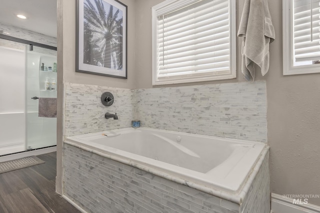 full bathroom featuring a garden tub, wood finished floors, and a shower stall