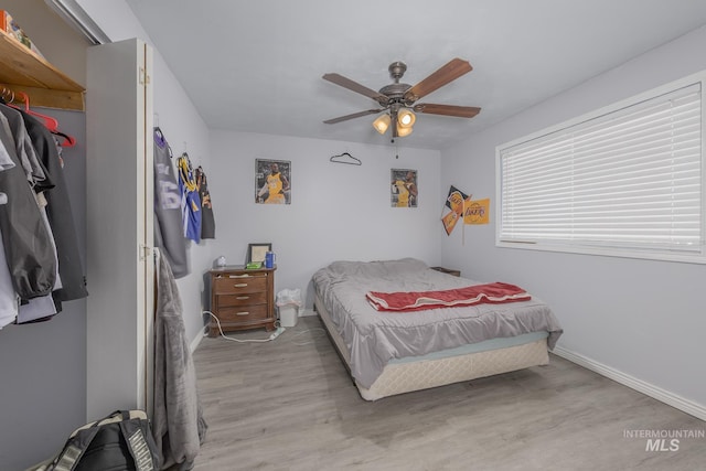 bedroom featuring ceiling fan, baseboards, and wood finished floors