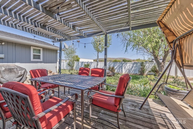 wooden deck featuring a pergola, outdoor dining area, and a fenced backyard