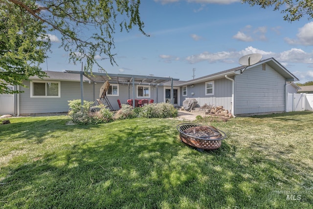 back of property with a yard, fence, a patio area, a pergola, and a fire pit