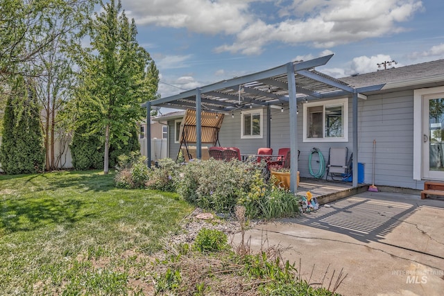 rear view of house with a lawn, a patio area, a wooden deck, and a pergola