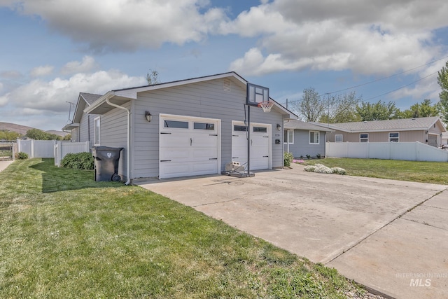 view of side of home featuring concrete driveway, an attached garage, fence, and a lawn