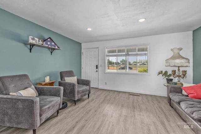sitting room with wood finished floors, baseboards, and recessed lighting