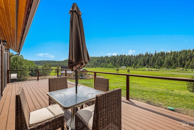 3383 Ridge Dr, Mccall, ID 83638 - wooden terrace with a wooded view, a yard, and outdoor dining space