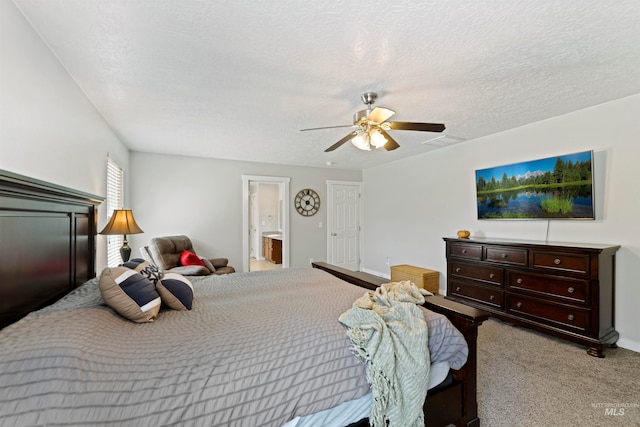 carpeted bedroom with ceiling fan, ensuite bath, visible vents, and a textured ceiling