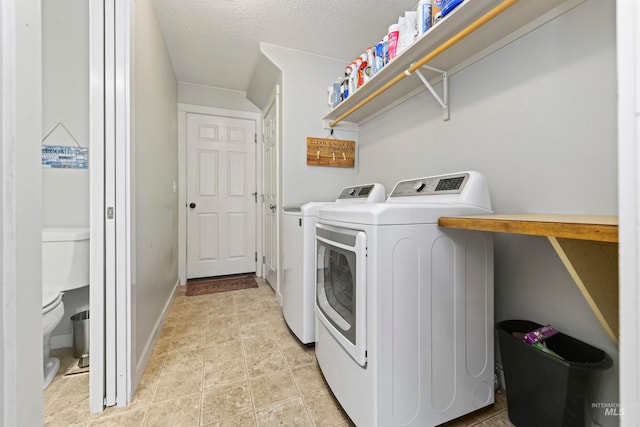 washroom with baseboards, light tile patterned floors, laundry area, a textured ceiling, and separate washer and dryer