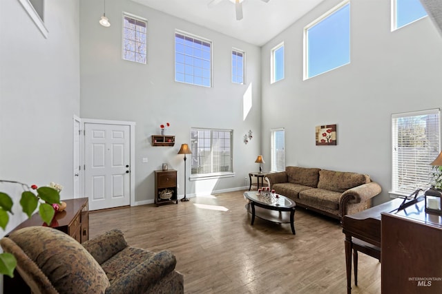 living room featuring a wealth of natural light, baseboards, and wood finished floors