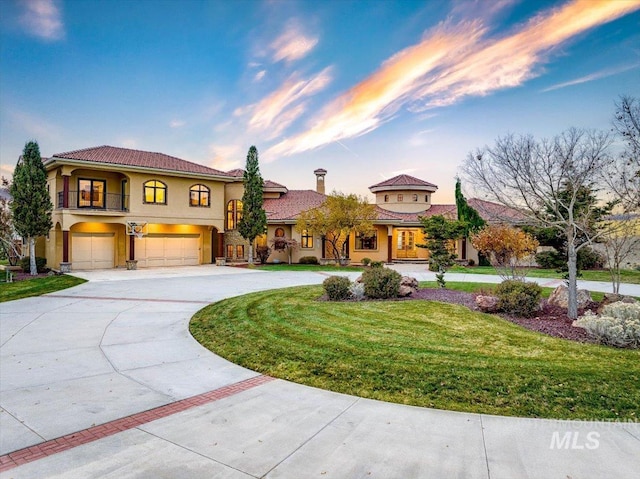 mediterranean / spanish-style house featuring a garage and a yard