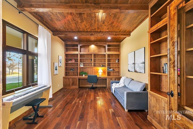 unfurnished room featuring built in desk, beam ceiling, dark hardwood / wood-style flooring, and wood ceiling