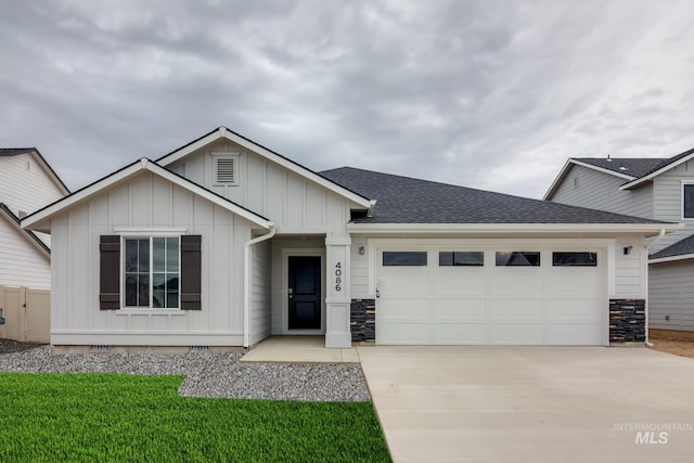 view of front of property featuring roof with shingles, stone siding, concrete driveway, a garage, and board and batten siding