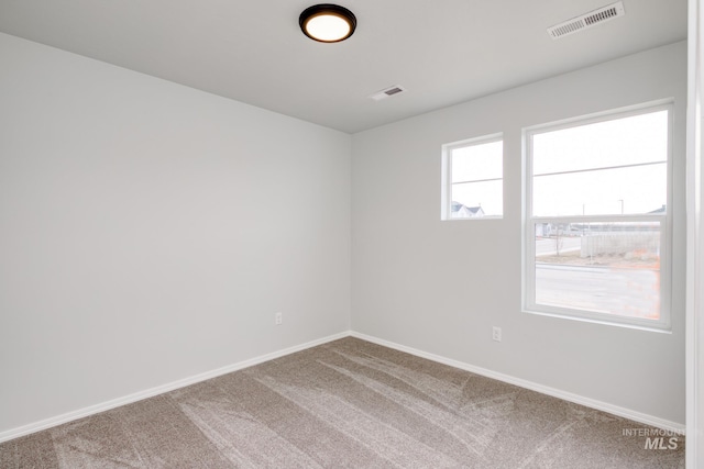 unfurnished room featuring baseboards, carpet flooring, and visible vents