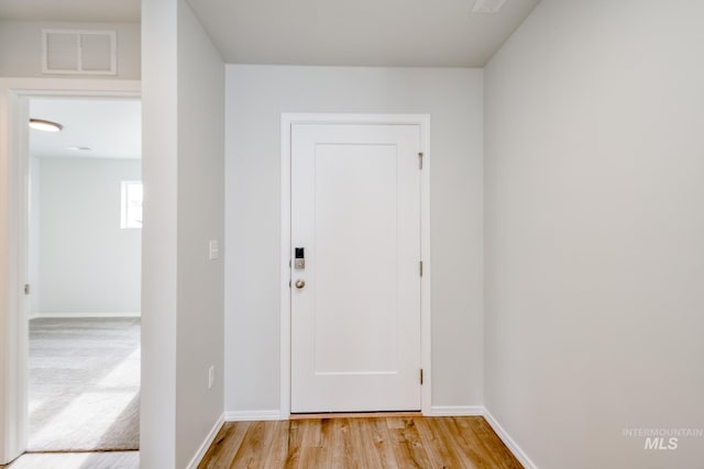 entryway with baseboards, visible vents, and light wood-style floors