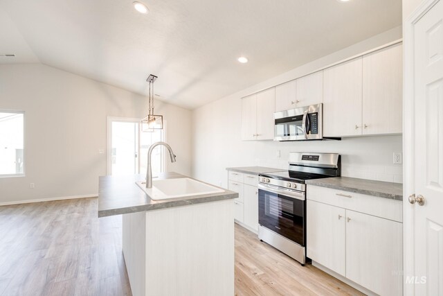 kitchen featuring plenty of natural light, lofted ceiling, stainless steel appliances, a sink, and light wood-style flooring
