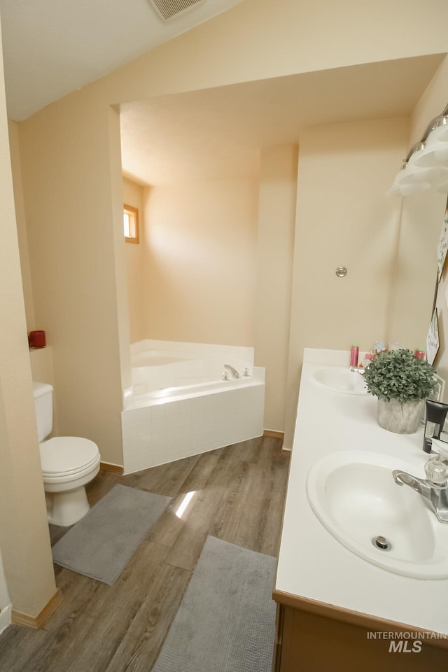 275 E Aruba, Meridian, ID 83642 - bathroom featuring wood finished floors, a bath, double vanity, toilet, and baseboards