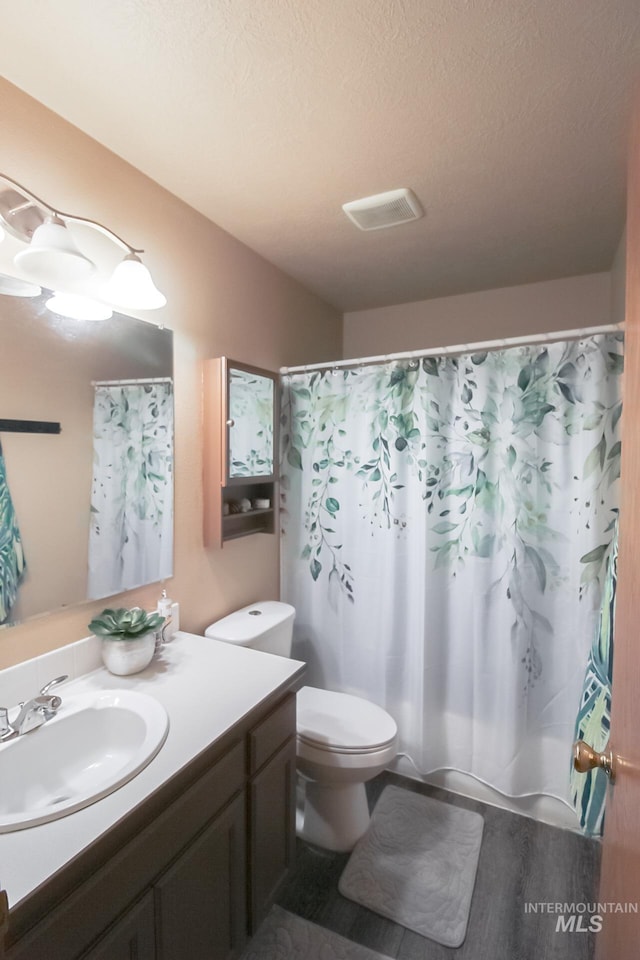 275 E Aruba, Meridian, ID 83642 - bathroom featuring vanity, toilet, curtained shower, and a textured ceiling