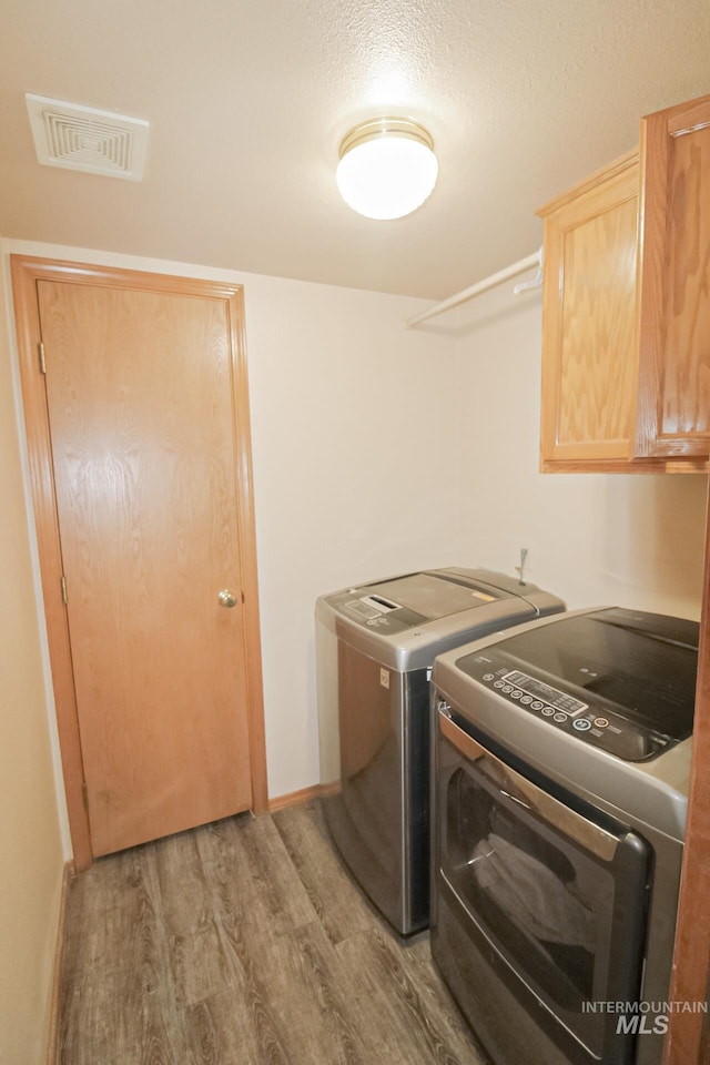 275 E Aruba, Meridian, ID 83642 - washroom with washer and clothes dryer, cabinet space, and wood finished floors