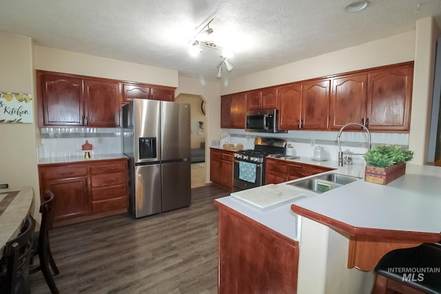 275 E Aruba, Meridian, ID 83642 - kitchen with stainless steel appliances, a sink, a peninsula, dark wood finished floors, and light countertops