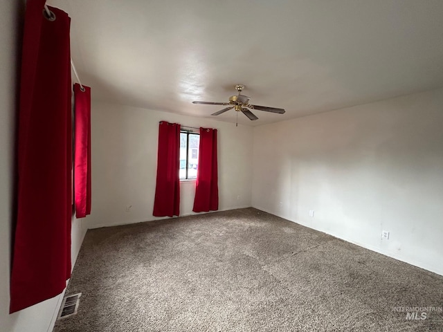 carpeted empty room featuring visible vents and a ceiling fan