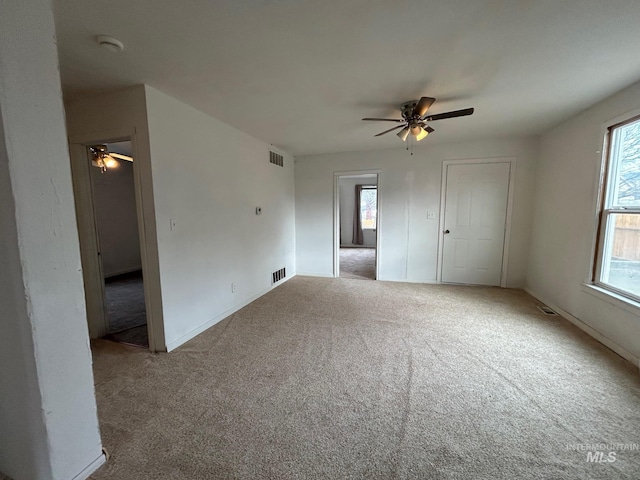 unfurnished bedroom with carpet floors, visible vents, and a ceiling fan